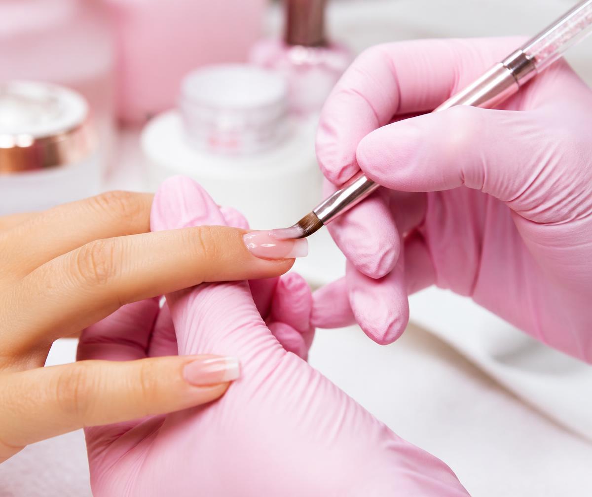 Nail technician demonstrating a gel extension technique